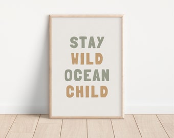 May include: A framed print with the text "STAY WILD OCEAN CHILD" in green and brown lettering on a white background.
