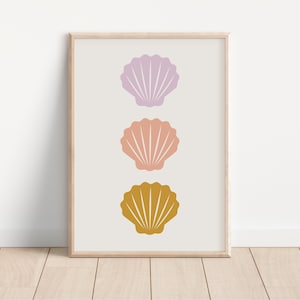 May include: A framed print featuring three stylised seashells arranged vertically. The shells are in shades of purple, pink, and yellow.