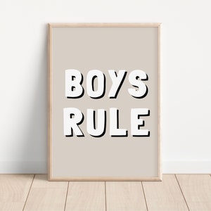 May include: A beige framed print with the text "BOYS RULE" in white block letters with black outlines.