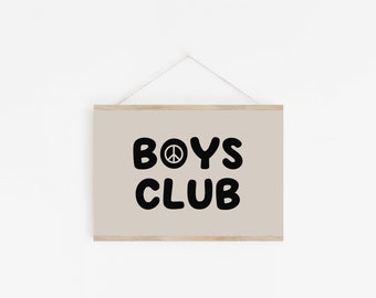 May include: A beige framed print with the text "BOYS CLUB" in black with a peace sign in the middle of the "O".