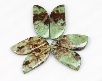Puede incluir: Cinco cabujones de piedra preciosa verde y marrón, cada uno con forma de media luna, dispuestos en forma de estrella.