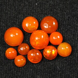 May include: A collection of ten orange opal cabochons of varying sizes. The cabochons are smooth and polished, with a slight sheen.