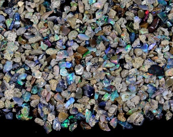 Könnte beinhalten: Nahaufnahme einer Sammlung roher Opal-Edelsteine. Die Opale zeigen eine Vielzahl von Farben, darunter Blau-, Grün- und schillernde Farbtöne. Die Steine sind mit einer Matrix aus grauem und braunem Gestein vermischt.