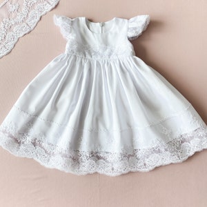 Vestido de bautizo de algodón blanco con mangas con volantes.
