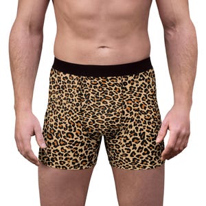Könnte beinhalten: Boxershorts mit Leopardenmuster. Die Shorts haben einen schwarzen Bund und ein braun-beiges Fleckenmuster. Das Kleidungsstück besteht aus einem weichen, bequemen Material.