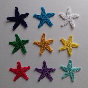 Könnte beinhalten: Neun gehäkelte sternförmige Verzierungen in verschiedenen Farben, darunter Blau, Weiß, Grün, Gelb, Rot, Lila und Türkis.