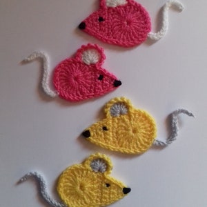 May include: Four crocheted mouse ornaments, two pink and two yellow, with white tails. The mice have black eyes and gray ears.