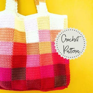 May include: A handmade crochet tote bag with a patchwork design in shades of red, pink, orange, yellow, and white. The bag has two handles and the text "Crochet Pattern" in a circular design.