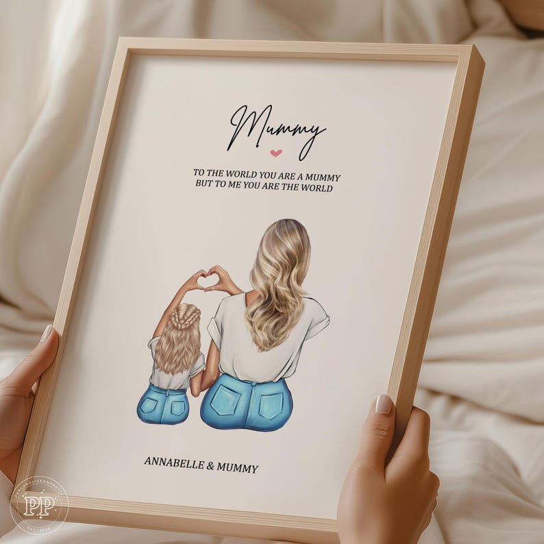 May include: A framed print featuring an illustration of a mother and child. The mother and child are depicted from the back, with the mother forming a heart shape with her hands. The text reads "Mummy" and "To the world you are a mummy but to me you are the world."