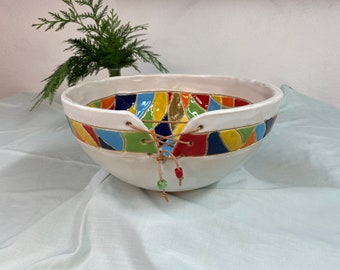 White bowl with leather lacing and colorful accents