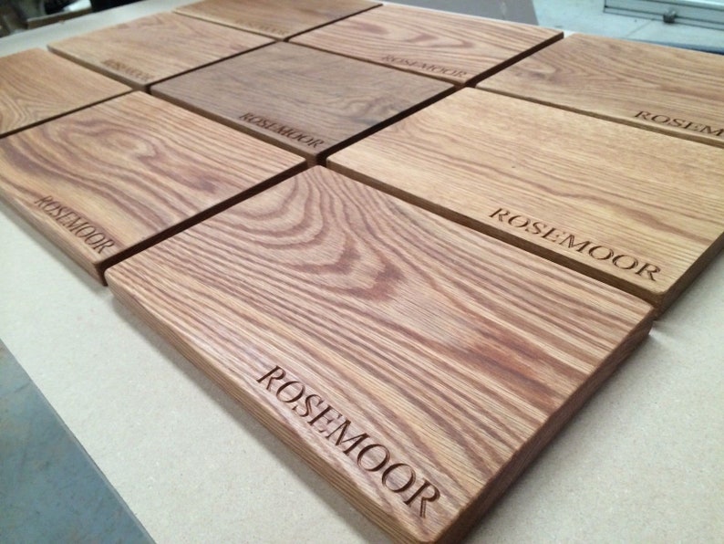 May include: A set of six wooden cutting boards with the text "Rosemoor" engraved on each board.