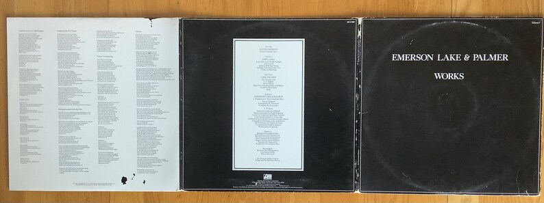May include: A black vinyl record album cover with the title "WORKS" and the artist "EMERSON, LAKE & PALMER" in white text. The back of the album cover has a white label with the track listing and credits.