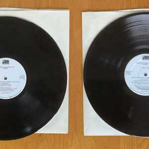 May include: Two black vinyl records in white paper sleeves. The record labels are visible and feature the text "I Wasn't Like It Should Be" and "Hardcore" with the band name "The Cure" on both labels.