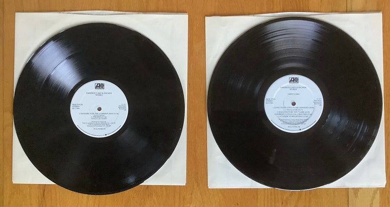 May include: Two black vinyl records in white paper sleeves. The record labels are visible and feature the text "I Wasn't Like It Should Be" and "Hardcore" with the band name "The Cure" on both labels.
