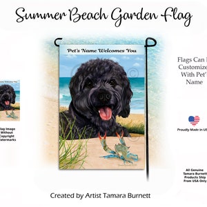 May include: A black and white garden flag with a black dog on a beach with a blue crab. The text on the flag reads "Pet's Name Welcomes You".