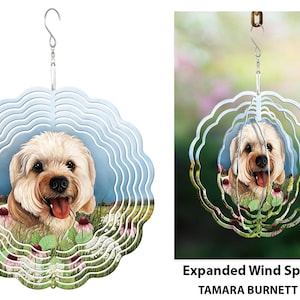 Könnte beinhalten: Ein dekorativer Windspinner mit einem lächelnden Hund in einem Blumenfeld. Der Hund hat hellbraunes Fell und eine rosa Zunge. Der Spinner hat ein mehrschichtiges, wellenförmiges Design mit einem Aufhängehaken.