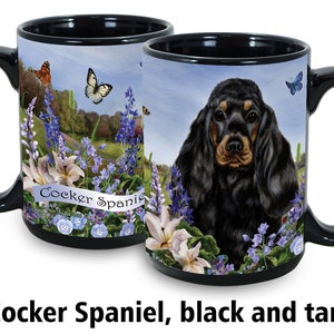 Puede incluir: Taza de perro Cocker Spaniel negro y fuego con diseño floral y mariposas. La taza tiene un borde y un asa negros. El texto "Cocker Spaniel" está impreso en la taza.