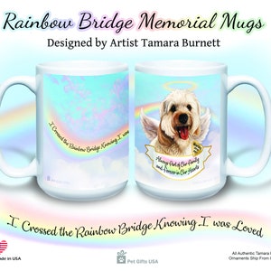 Könnte beinhalten: Weiße Keramik-Tasse mit einem Design mit Regenbogen, Wolken und einem Hund mit Engelsflügeln. Text enthält "Rainbow Bridge Memorial Mugs" und "I Crossed the Rainbow Bridge Knowing I was Loved." Entworfen von Künstlerin Tamara Burnett.