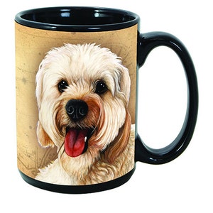 Könnte beinhalten: Schwarz-weiße Keramik-Kaffeetasse mit einer detaillierten Illustration eines flauschigen, hellbraunen Hundes mit roter Zunge. Die Tasse hat einen schwarzen Innenraum und Griff sowie einen beigefarbenen Hintergrund mit einem Kartendesign.