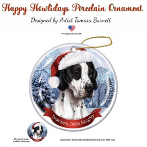 May include: A round porcelain ornament featuring a black and white dog wearing a Santa hat, set against a snowy winter scene. The ornament has the text "Dear Santa, Define Naughty" and "Happy Howlidays Porcelain Ornament". Designed by Artist Tamara Burnett.