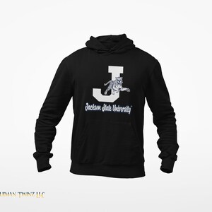 May include: Black hooded sweatshirt with a white letter J and a white tiger inside the letter. The text "Jackson State University" is below the letter.