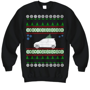 Peut inclure: Pull-over de Noël noir avec une voiture blanche et un sapin de Noël vert. Le pull-over a un motif de flocons de neige rouge et blanc.