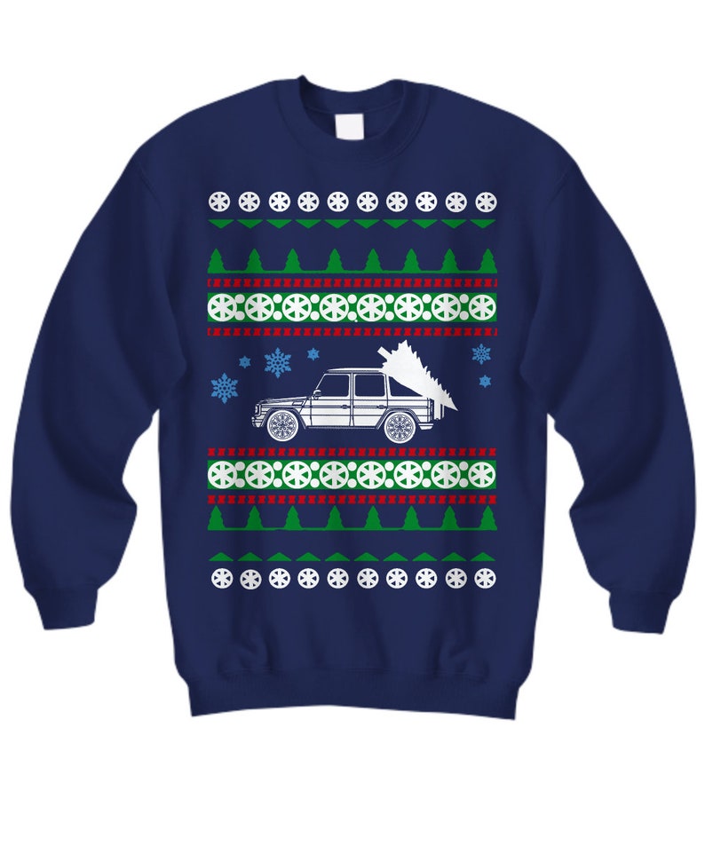 May include: A navy blue Christmas sweater with a white silhouette of a car carrying a Christmas tree. The sweater has a red and white snowflake pattern, green trees, and white tire designs.