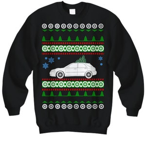 May include: Black Christmas sweater with a white car and a green Christmas tree on it. The sweater has a red and white snowflake pattern.