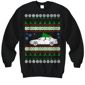 May include: Black Christmas sweater with a white car and a green Christmas tree on top. The sweater has a red and white snowflake pattern.