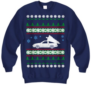 Pode incluir: Camisola azul marinho com um carro branco a transportar uma árvore de Natal. O design inclui árvores verdes, círculos vermelhos e brancos e flocos de neve. Uma camisola festiva de Natal.