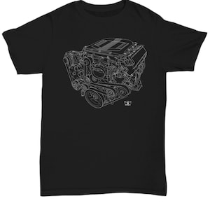 Op de afbeelding: Een zwart T-shirt met een witte omtrek van een auto-motor. De motor is gedetailleerd met al zijn onderdelen, inclusief de zuigers, krukas en nokkenas.