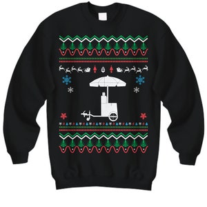 May include: Black sweatshirt with a festive Christmas design. The design includes a white food cart, snowflakes, reindeer, Christmas trees, and a red, green, and white pattern. A fun and unique holiday sweater.