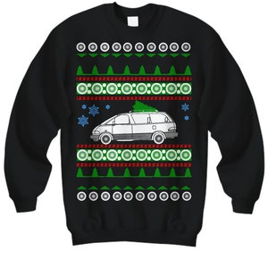 May include: Black Christmas sweater with a white minivan carrying a green Christmas tree. The sweater has a red and white snowflake pattern and a green and white circle pattern.