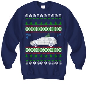 May include: Navy blue sweatshirt with a festive design. The design includes a white car with a Christmas tree on top, surrounded by green trees, snowflakes, and circular patterns in red, white, and green. A fun holiday sweater.