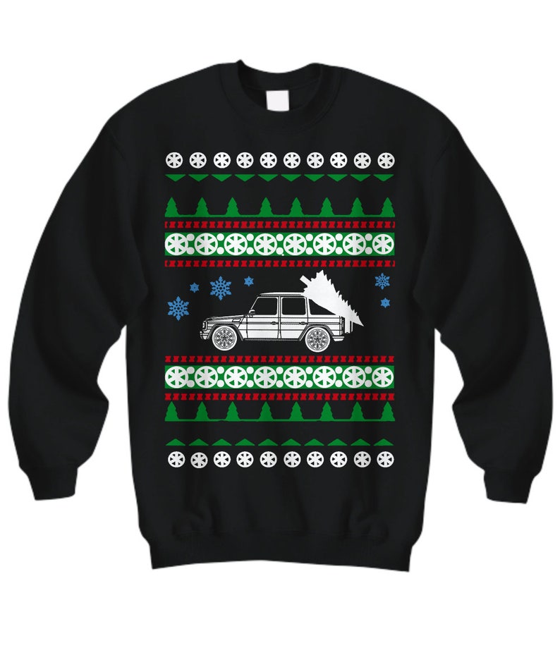 May include: Black Christmas sweater with a white silhouette of a car carrying a Christmas tree. The sweater has a red, white, and green pattern with snowflakes and tire tracks.