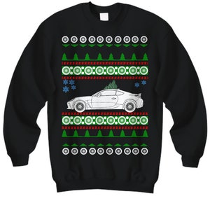 May include: Black Christmas sweater with a white car and green Christmas trees. The sweater has a red and white pattern.