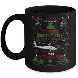 May include: Black ceramic mug with a festive Christmas design. The mug features a helicopter graphic and the text "Spreading Christmas Cheer and a Happy New Year" in red and green. The design includes snowflakes and Christmas trees.