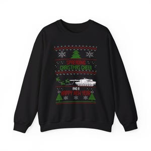 Puede incluir: Sudadera negra con un diseño navideño que presenta un tanque tirando de un trineo con renos. El texto dice "Spreading Christmas Cheer and a Happy New Year".
