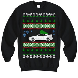 Könnte beinhalten: Schwarzer Weihnachtspullover mit einem weißen Auto und einem Weihnachtsbaum darauf. Der Pullover hat ein rotes und grünes Muster mit Schneeflocken.