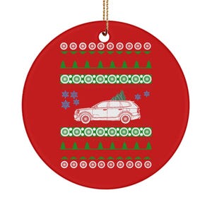 May include: A round, red Christmas ornament with a white car carrying a Christmas tree. The ornament has a festive pattern of green trees, white circles, and snowflakes. A gold string is attached for hanging.