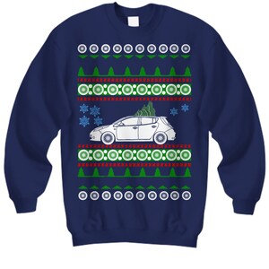 May include: A navy blue Christmas jumper with a white car and a green Christmas tree on a red and white patterned background.