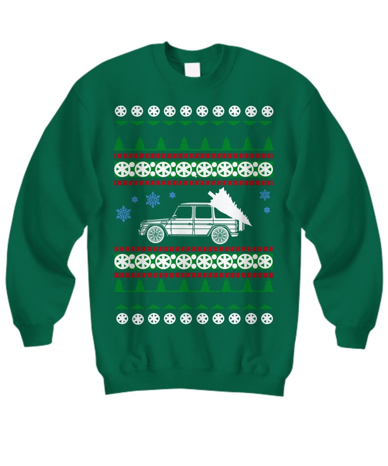 May include: Green Christmas sweater with a white car carrying a Christmas tree. The sweater has a repeating pattern of snowflakes, trees, and circles.