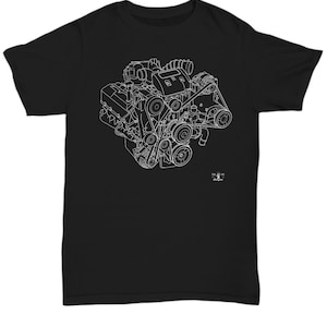 Könnte beinhalten: Schwarzes T-Shirt mit einer weißen Strichzeichnung eines Motors. Das Design zeigt die inneren Komponenten eines Motors, einschließlich Riemen, Riemenscheiben und Zylindern. Das T-Shirt hat einen Rundhalsausschnitt und kurze Ärmel. Ein kleines Logo befindet sich in der unteren rechten Ecke.