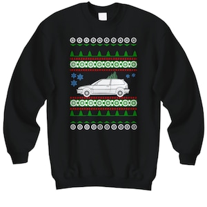 May include: Black Christmas sweater with a white car and a Christmas tree on top. The sweater has a green, red, and white pattern.