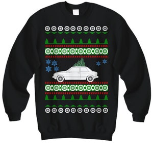 May include: Black Christmas sweater with a white car and a green Christmas tree on top. The sweater has a red and green snowflake pattern.