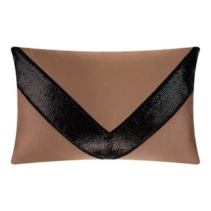 May include: A brown throw pillow with a black, sequined chevron design.