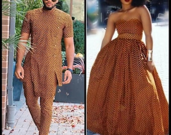 Può includere: Una coppia che indossa abiti abbinati con un motivo geometrico marrone e giallo. L'uomo indossa una camicia a maniche corte e pantaloni. La donna indossa un abito senza spalline. Entrambi indossano occhiali da sole.