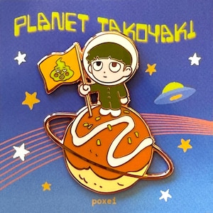 Puede incluir: Un pin de esmalte metálico con un personaje de dibujos animados en traje espacial de pie sobre una bola de takoyaki naranja redonda con un anillo, sosteniendo una bandera amarilla con una cara verde. Fondo azul con estrellas y el texto PLANET TAKOYAKI y poxei.
