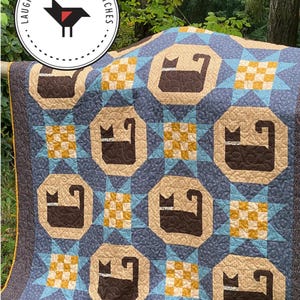 May include: A blue, tan, and yellow quilt with a cat design. The quilt features repeating cat silhouettes in brown, surrounded by tan octagons and blue star patterns. The quilt measures 58" x 82" and 46" x 46". The text "MIDNIGHT PROWL" is at the top.