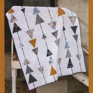 May include: White quilt with a repeating pattern of upward-pointing triangles in various colors, including gray, gold, and blue. The quilt is labeled "Sergeant Pepper" and features the "Abbey Lane Quilts" logo.